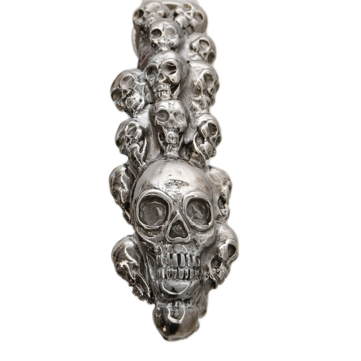 Top of the handle: a cluster of sculpted skulls in polished silver-tone brass, close-up, handcrafted in Italy