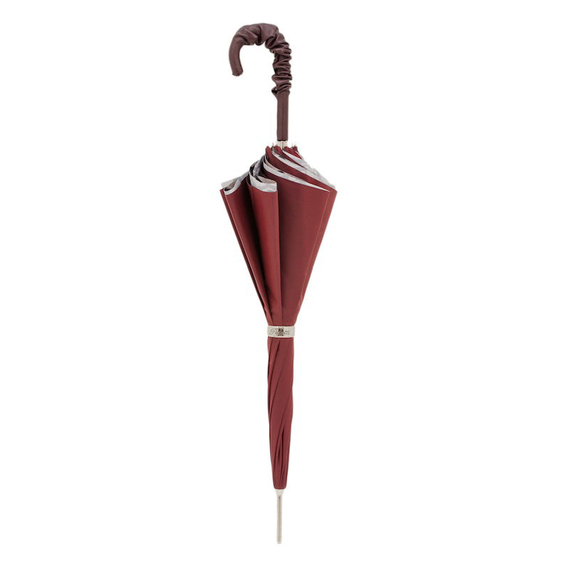Closed Pasotti burgundy cane umbrella standing upright