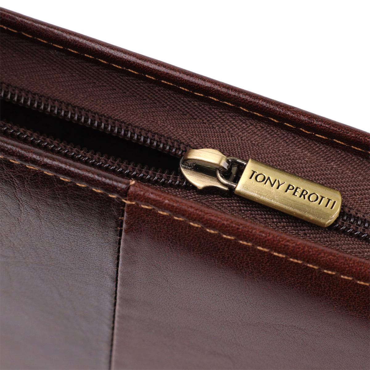 Close-up of the antique brass zip puller engraved Tony Perotti on the dark brown Italico 1278L padfolio