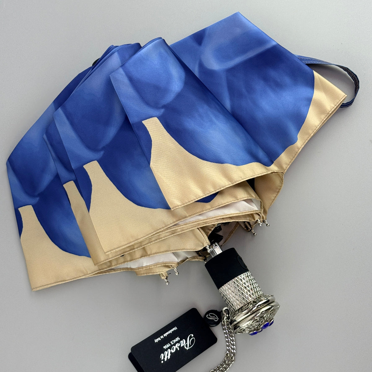 Pasotti blue folding umbrella with a floral print and a lace-patterned handle