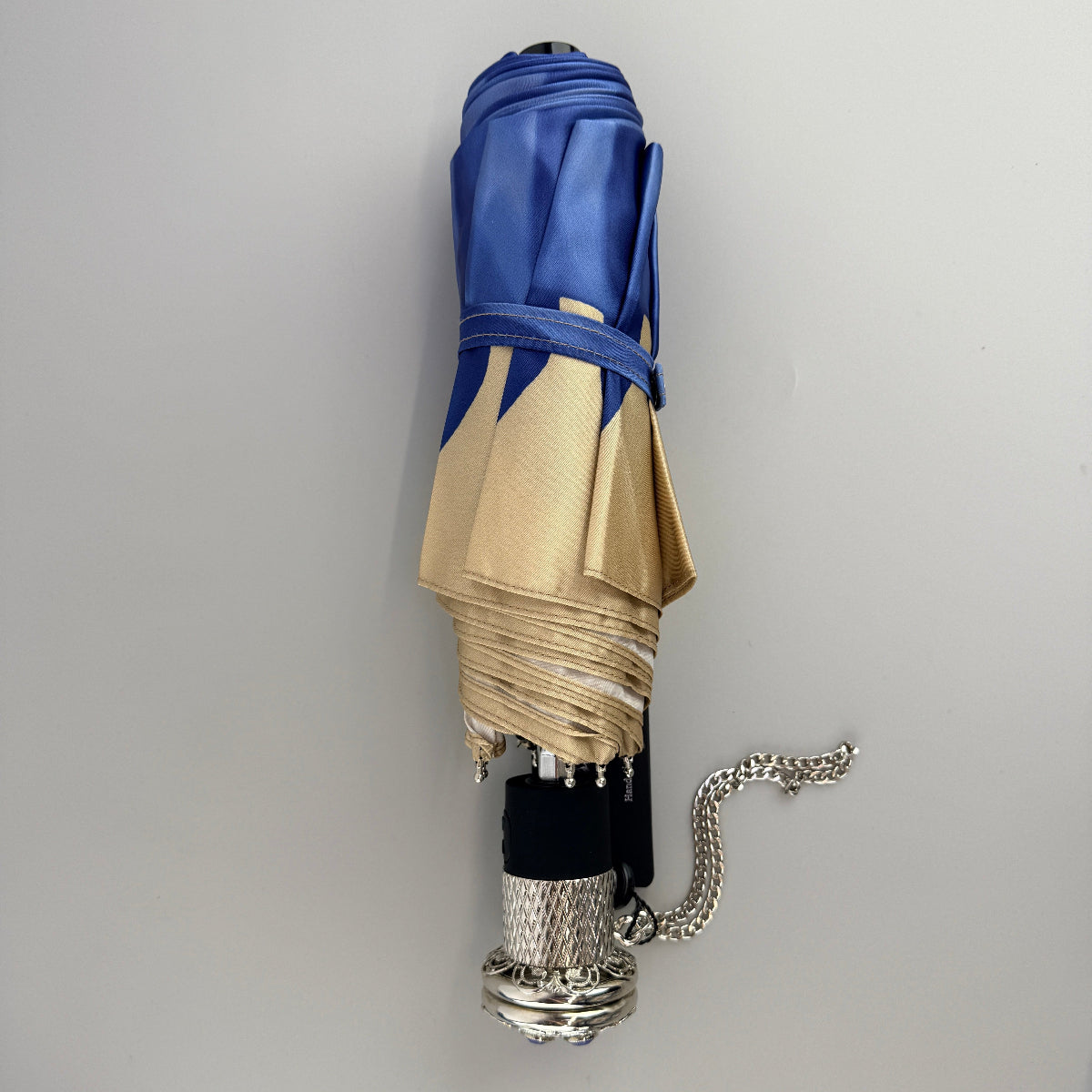 Pasotti blue umbrella with a floral print, when folded