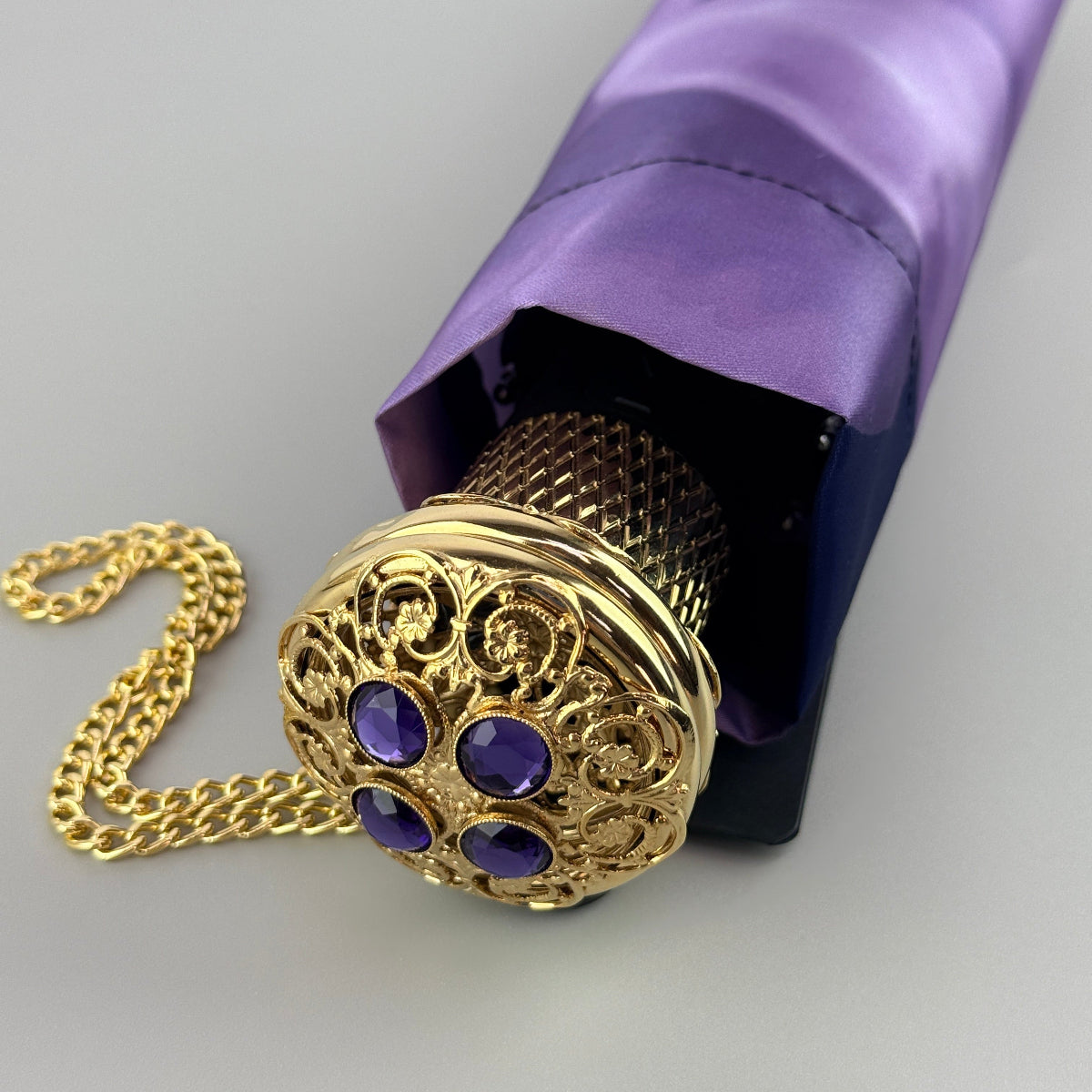 Pasotti folding purple umbrella with an golden handle
