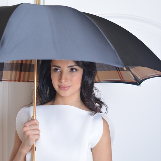 Woman holding a checkered umbrella against a white background