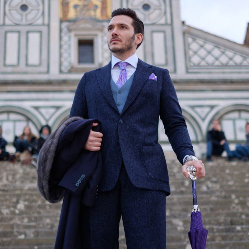 A man holds a purple Pasotti cane umbrella with a lion-shaped handle 1