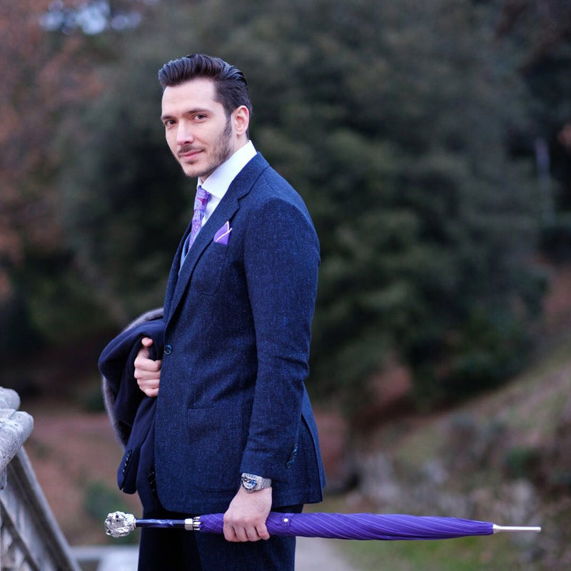 A man holds a purple Pasotti cane umbrella with a lion-shaped handle 2