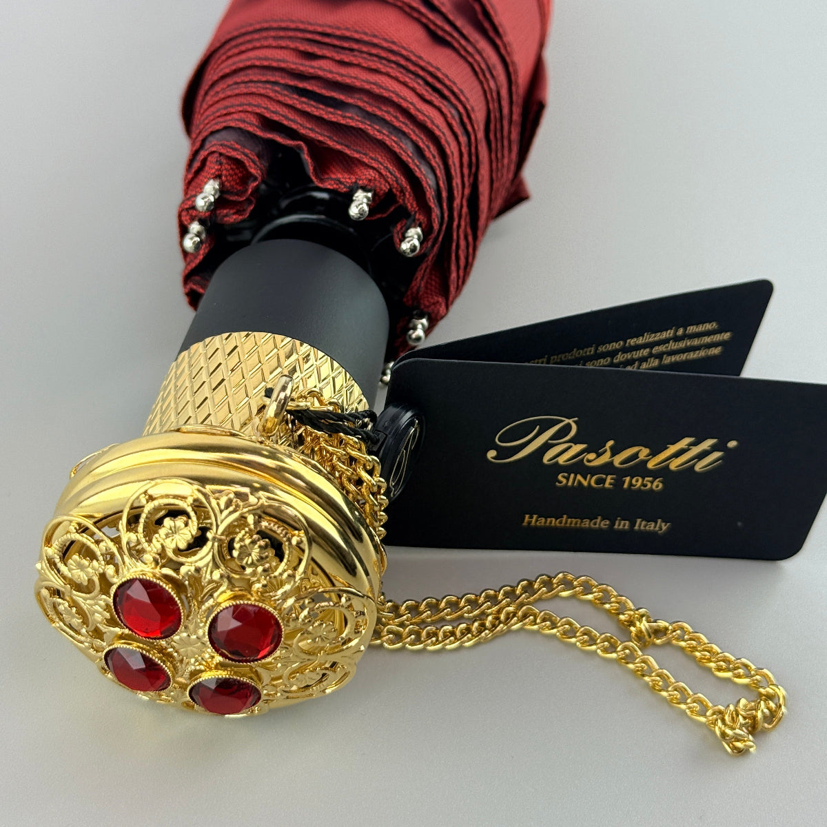 Red umbrella with gold decorative handle and chain, Pasotti brand card visible
