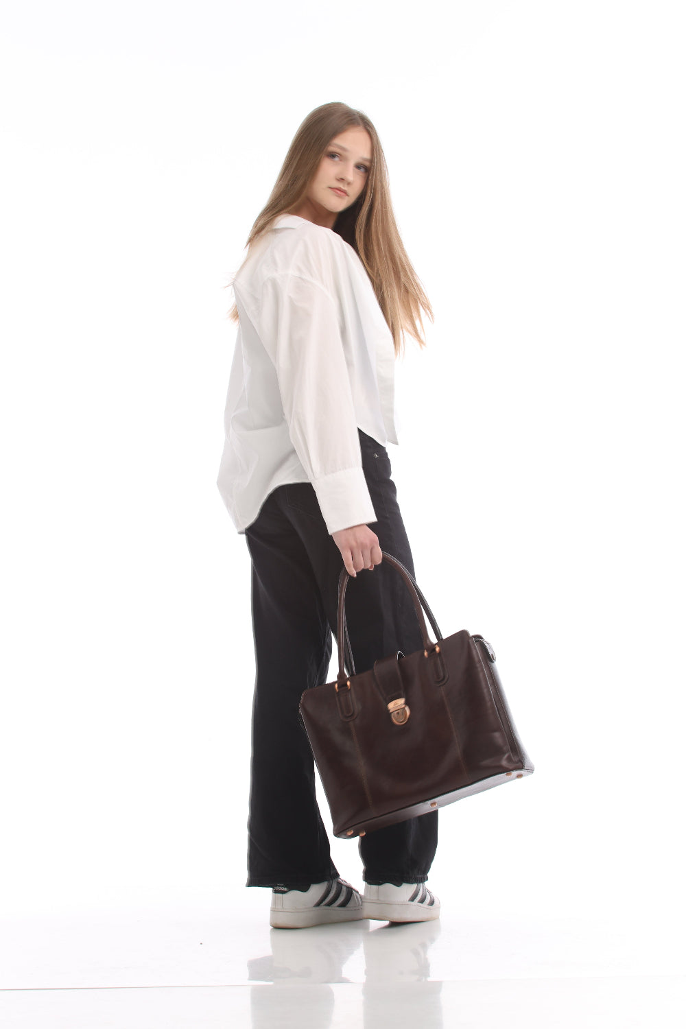 Woman seen from behind holding the Tony Perotti Italico 9715-40 moro leather laptop bag, showing the plain back panel of the bag