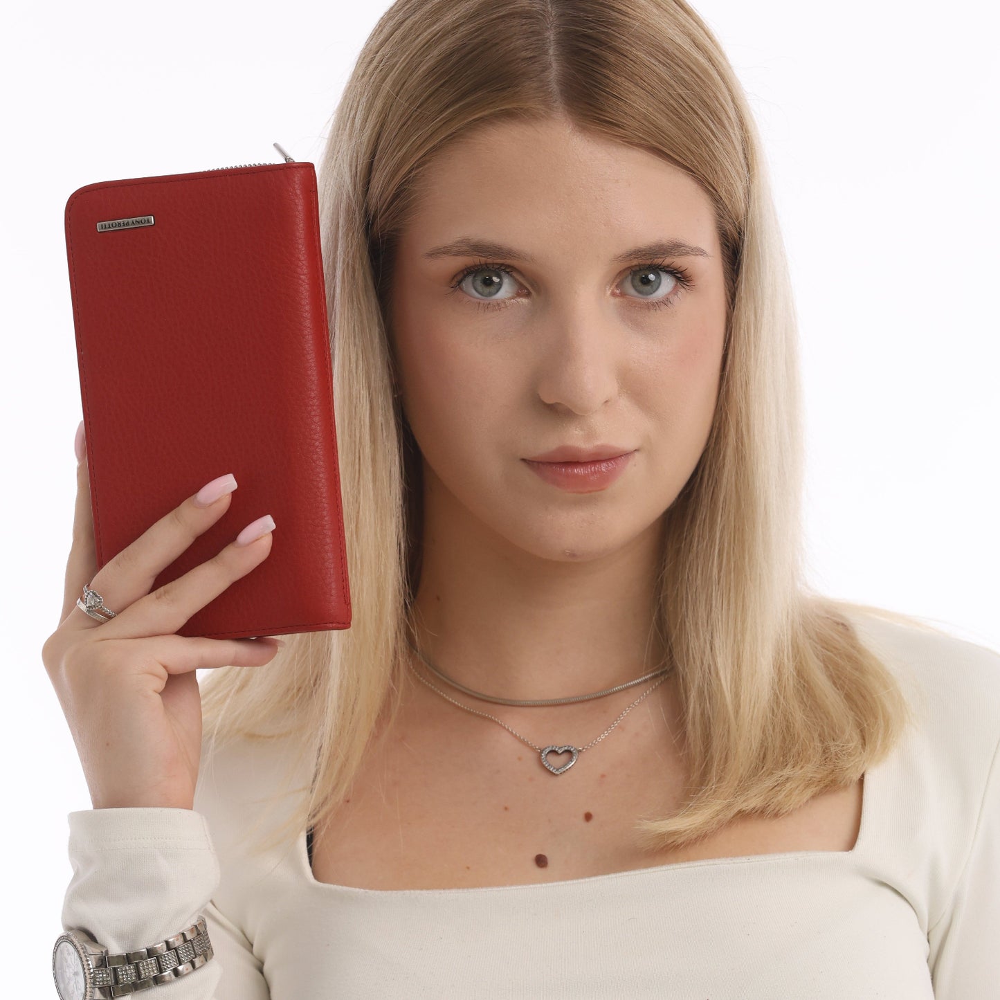 Woman holding a red leather zip wallet against a white background
