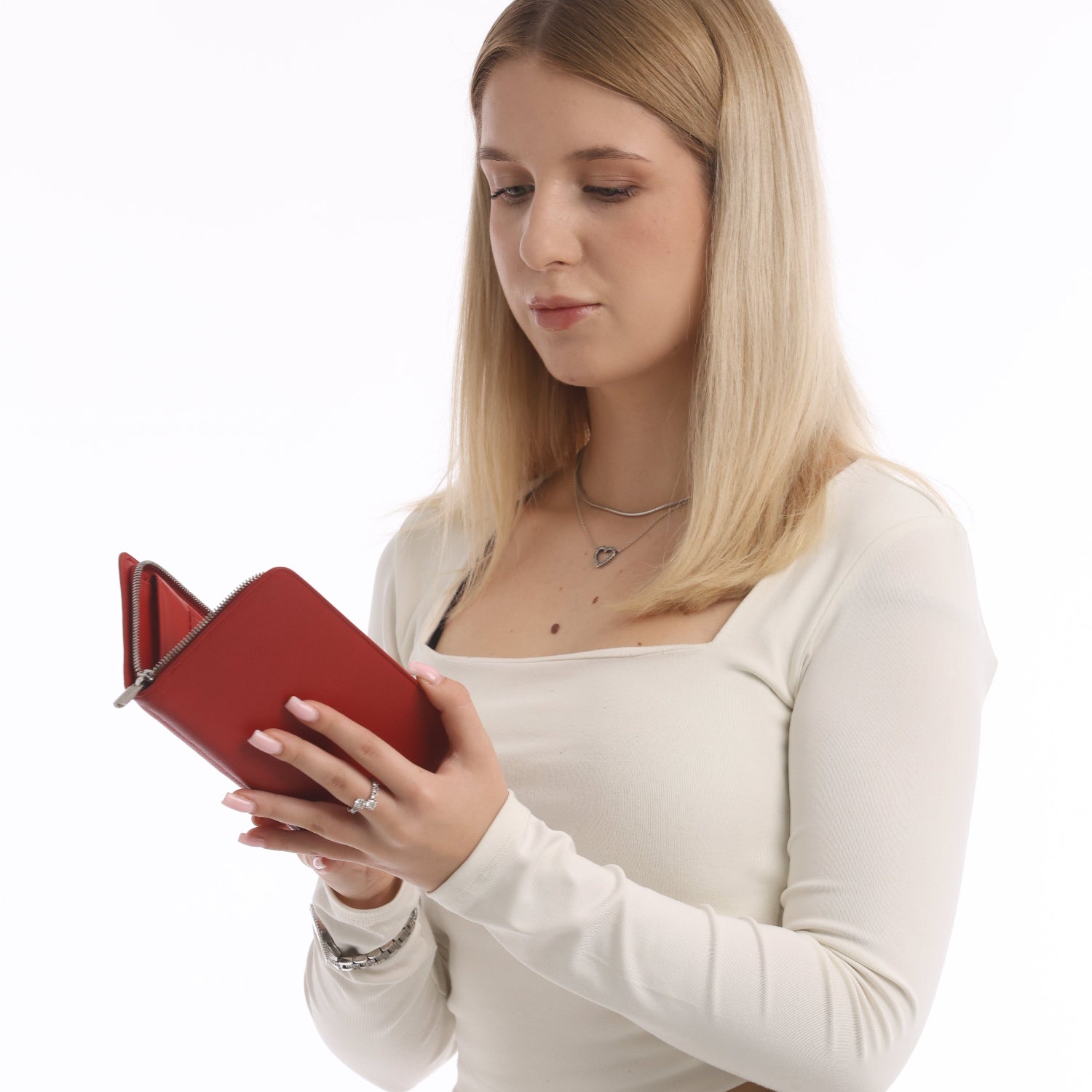 Woman holding a red leather zip wallet against a white background