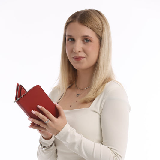 Woman holding a red leather zip wallet against a white background