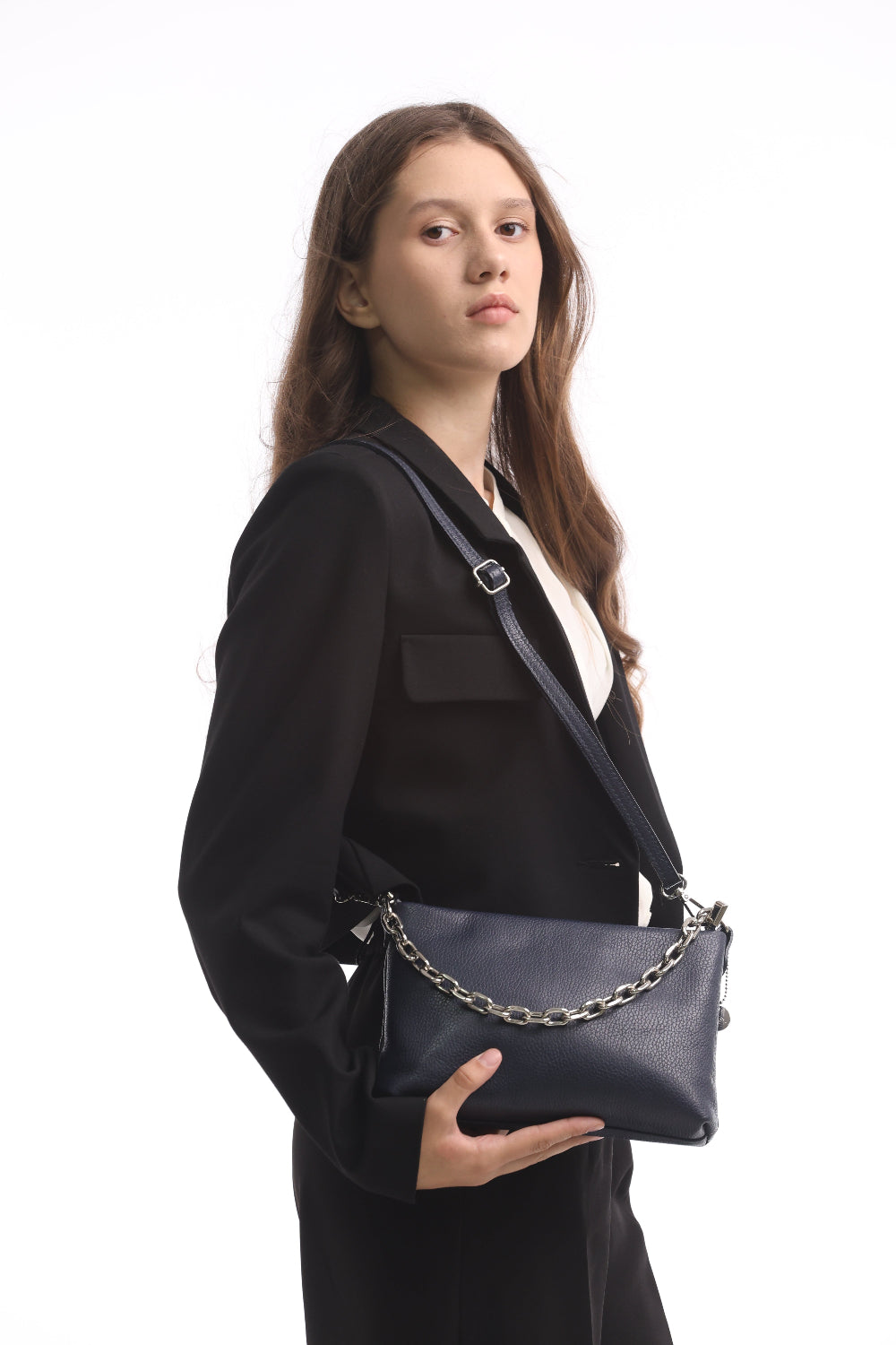 Woman wearing the navy Tony Perotti Borsa CA045-01BL bag across the body on its adjustable leather strap, steadying it with one hand