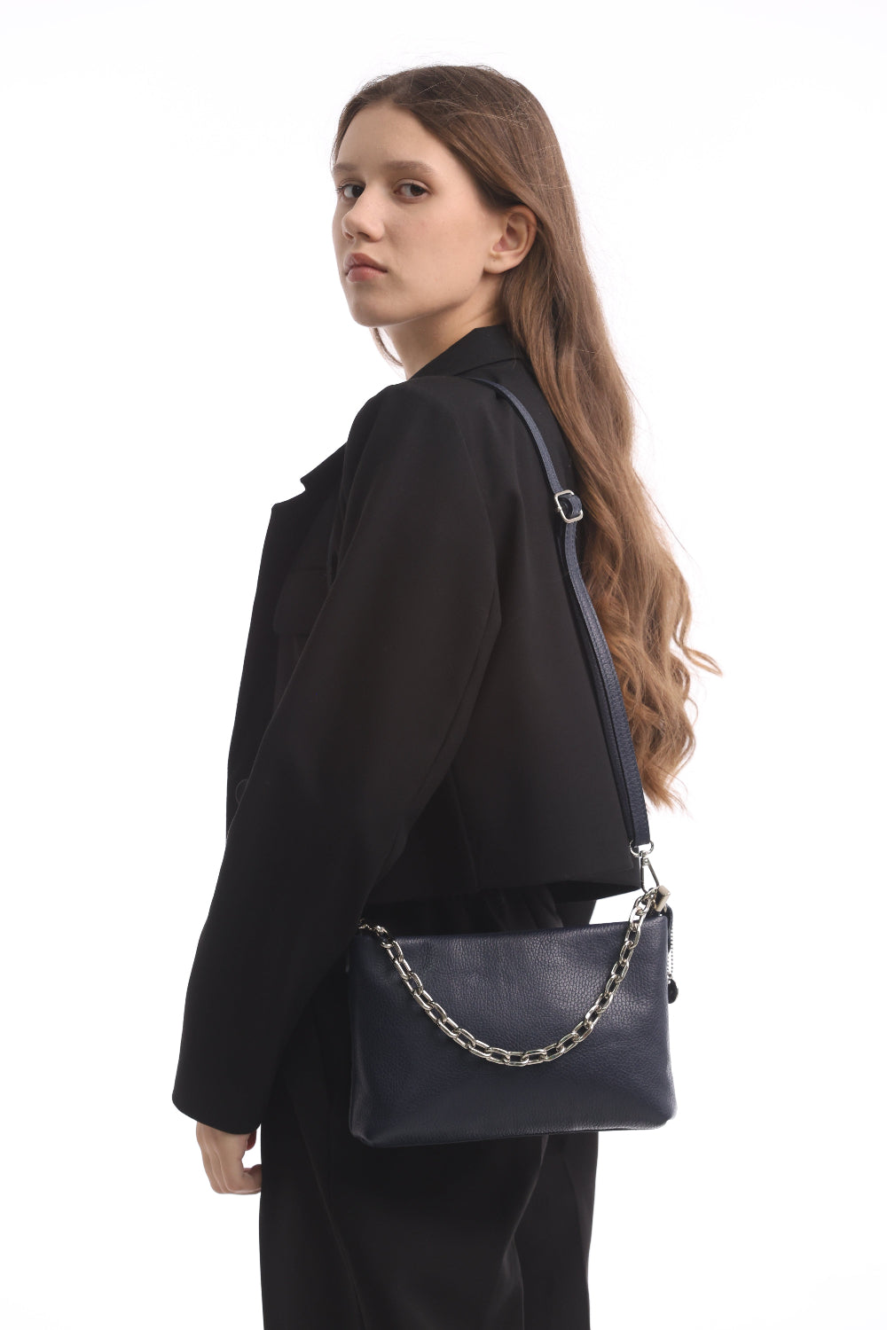 Woman seen from behind with the navy Tony Perotti Borsa CA045-01BL bag on the long leather strap, the buckle that adjusts the strap visible at the shoulder