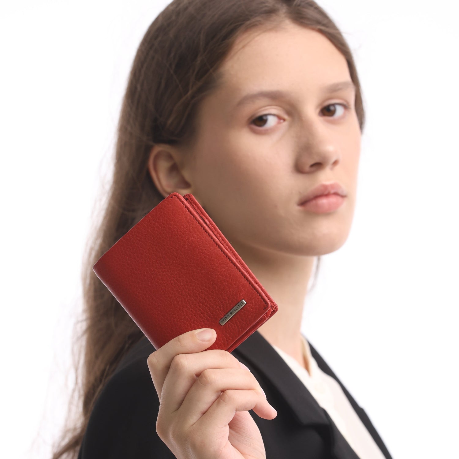 Person holding a red wallet in front of their face on a white background