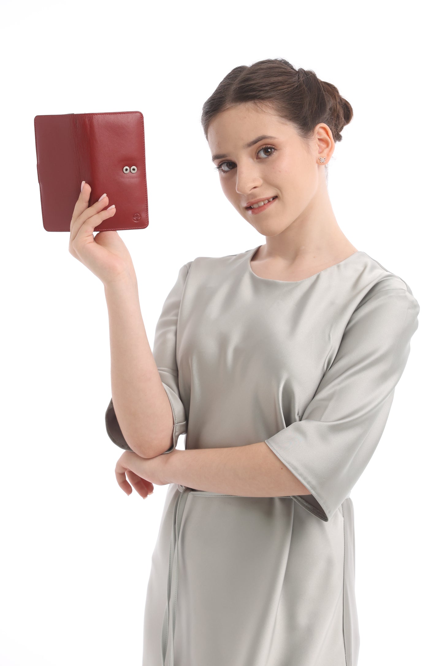 Back of the red Tony Perotti Cortina 5074 wallet held up by the model — the two press-stud caps of the strap