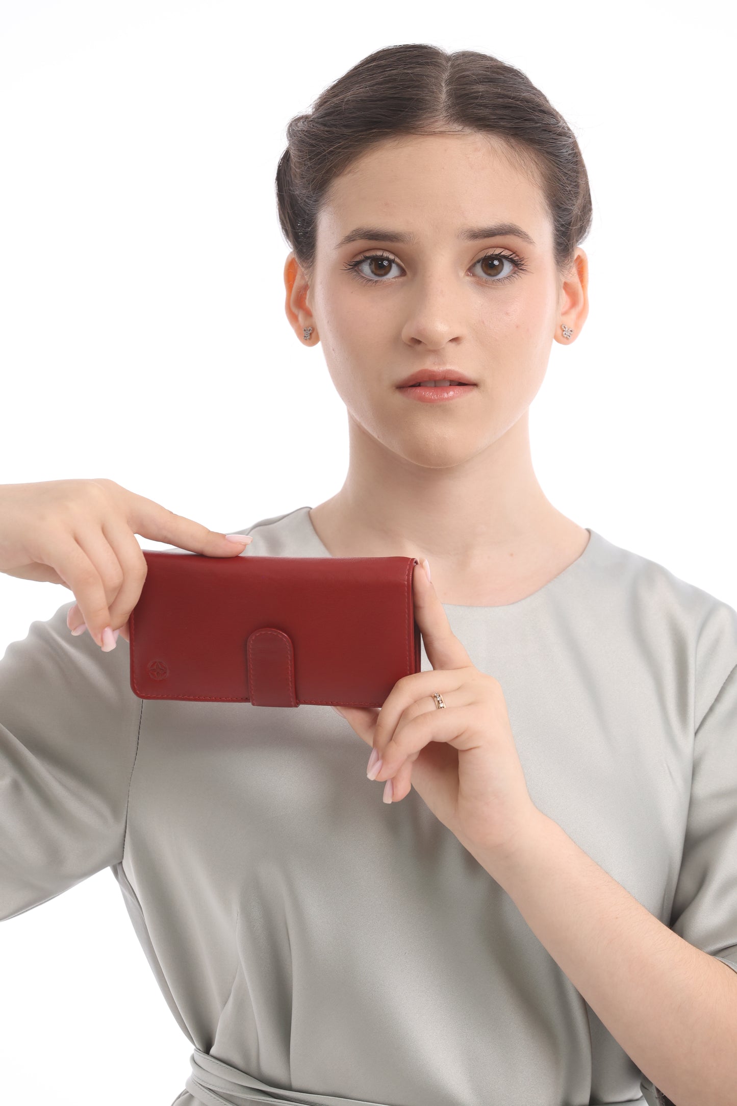 Model holding the red Tony Perotti Cortina 5074 wallet horizontally, front with the snap strap fastened