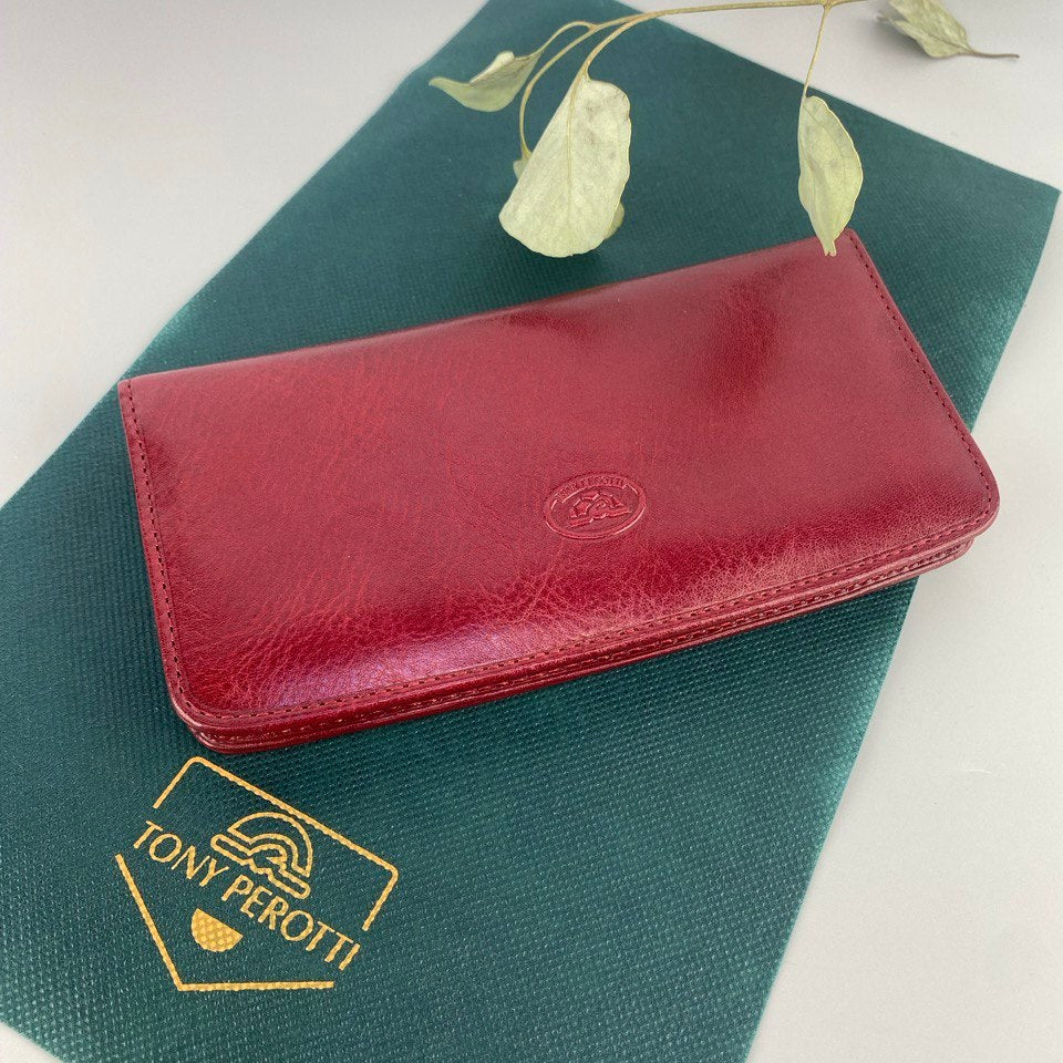 Red wallet on a green surface with Tony Perotti branding