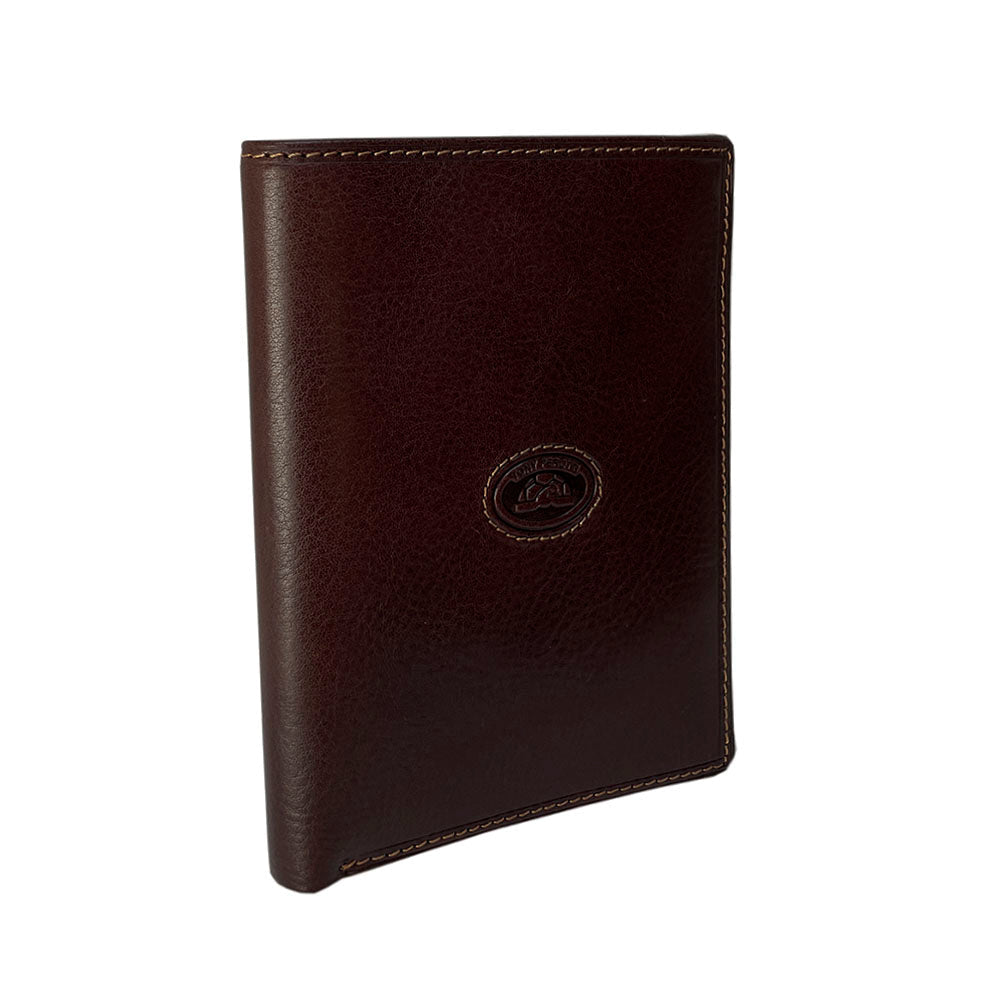 Angled view of the dark brown Tony Perotti Italico 3450Q moro passport wallet showing the embossed turtle emblem and contrasting light-beige stitching