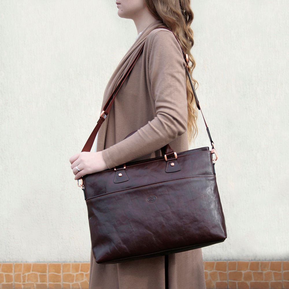 Woman carrying the dark brown Tony Perotti Italico 9625 business bag on the shoulder by its detachable strap
