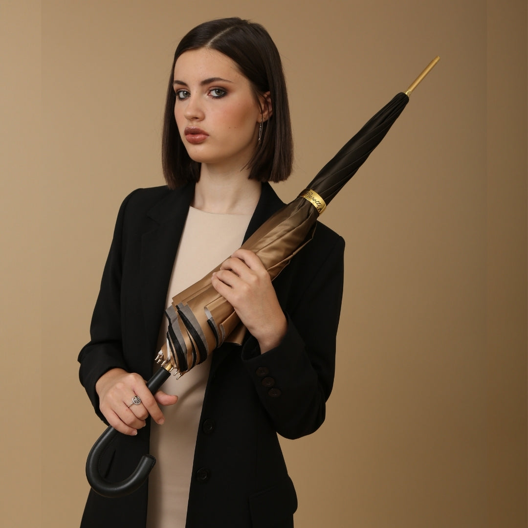 Woman holding a brown umbrella against a brown background