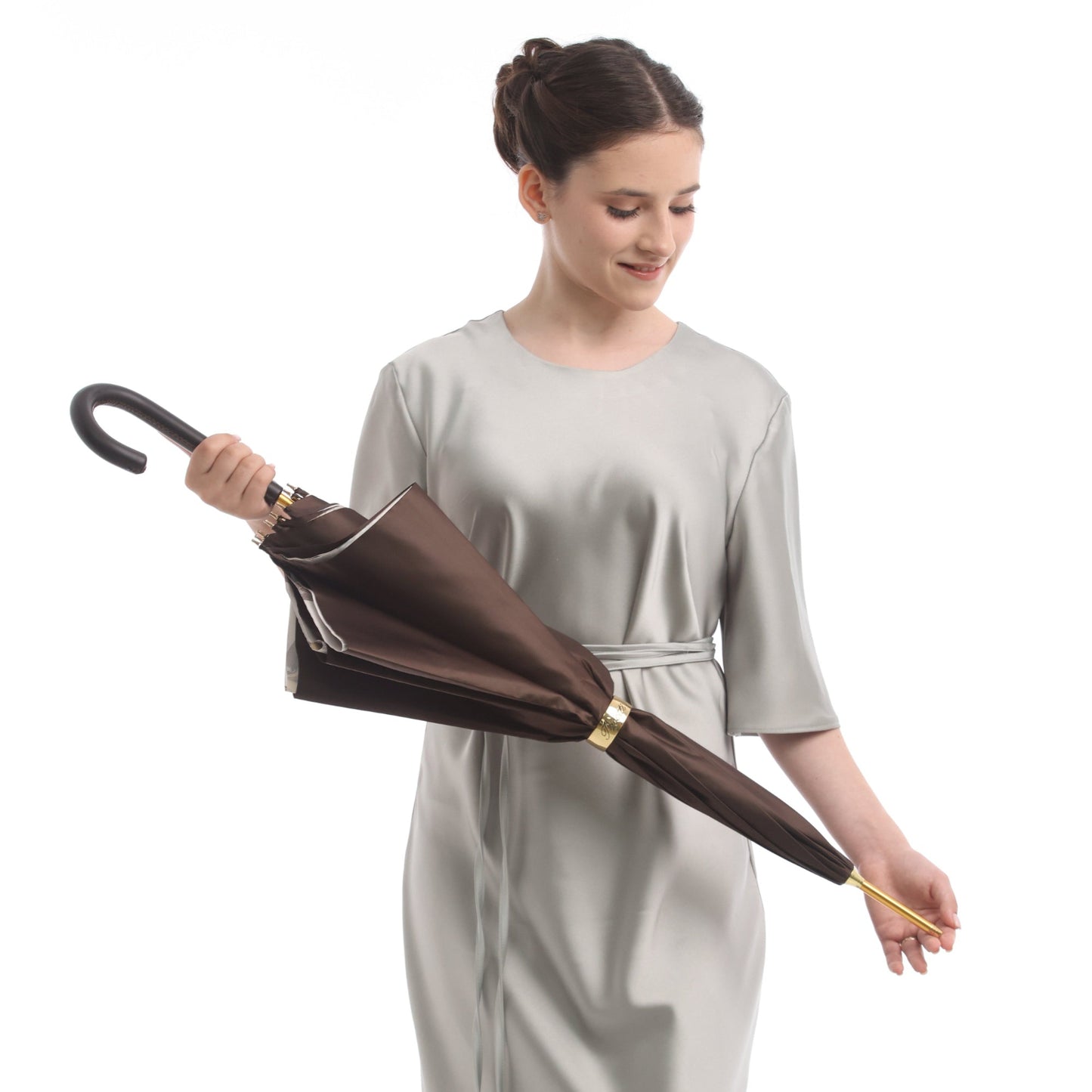 Model holding closed brown Pasotti umbrella