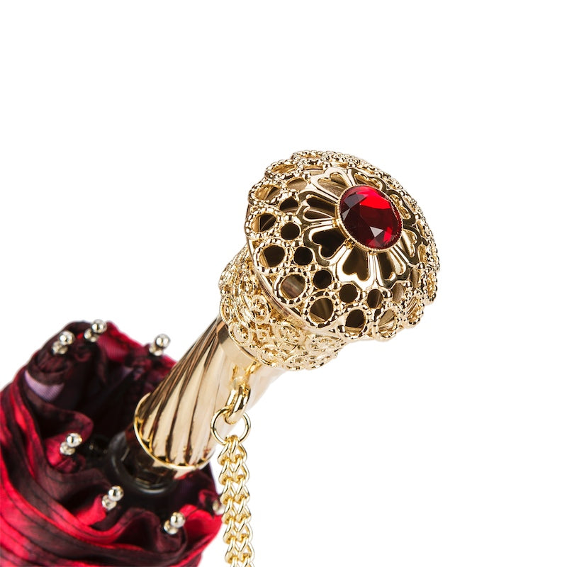 Close-up of Pasotti umbrella handle with gold-tone finish and red crystal accent