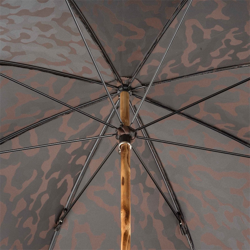 Underside of the camouflage canopy: eight ribs and a knotted natural wood shaft