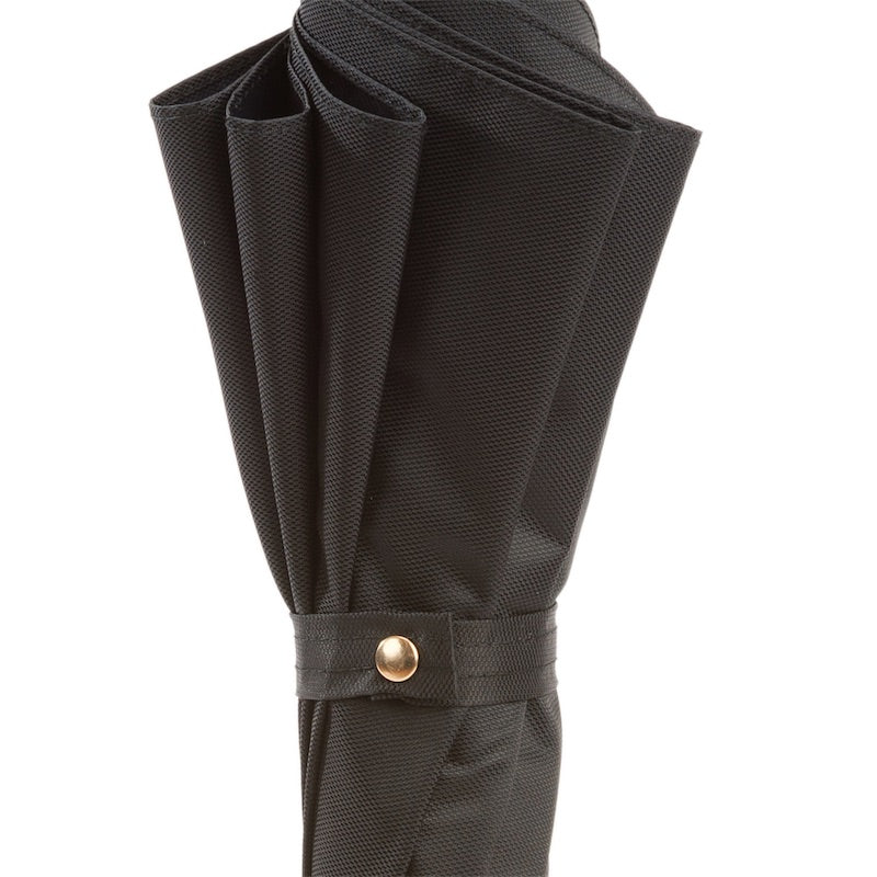 Furled canopy close-up: fine textured black fabric and strap with gold-tone snap button