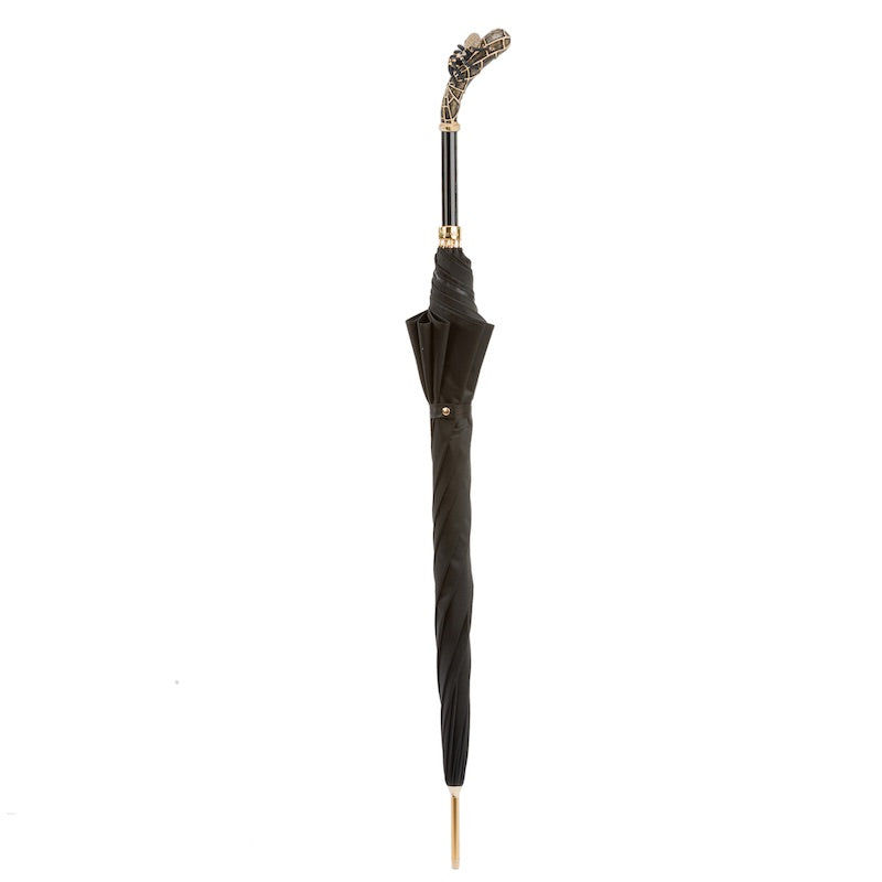 Closed black umbrella standing upright with the tarantula handle on top