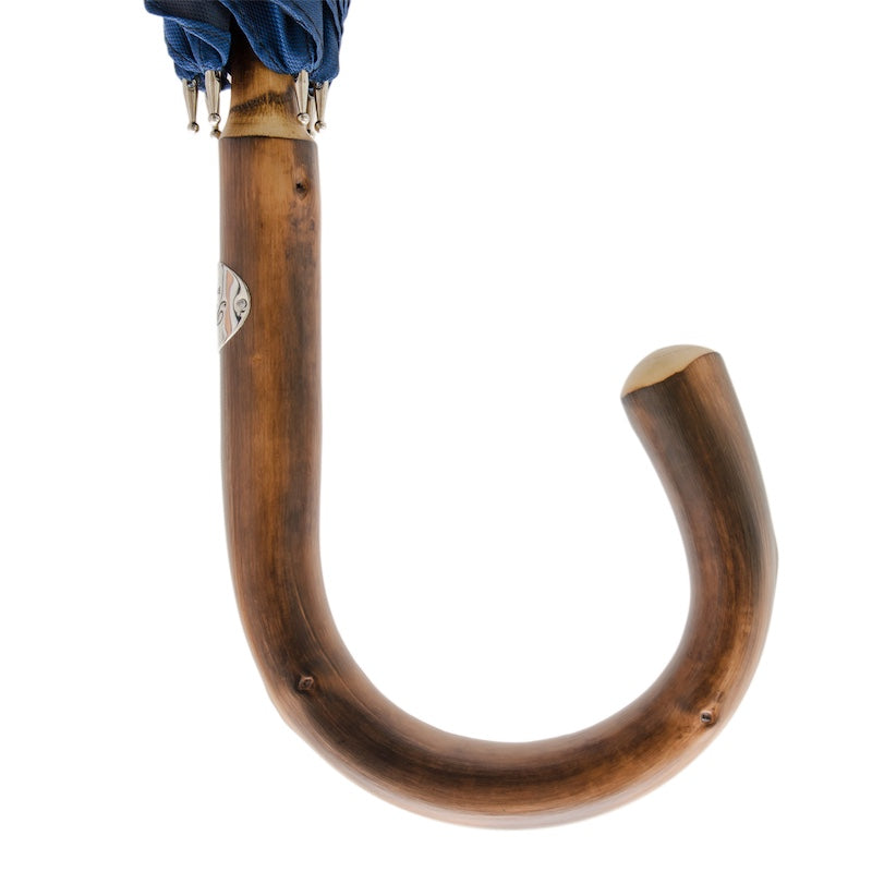 Chestnut crook handle with natural knots and silver-tone Pasotti plaque, close-up, handcrafted in Italy