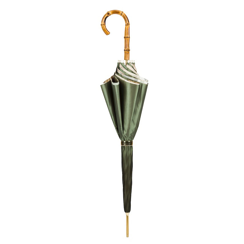 Closed green umbrella standing upright with the bamboo crook handle and gold-tone tip