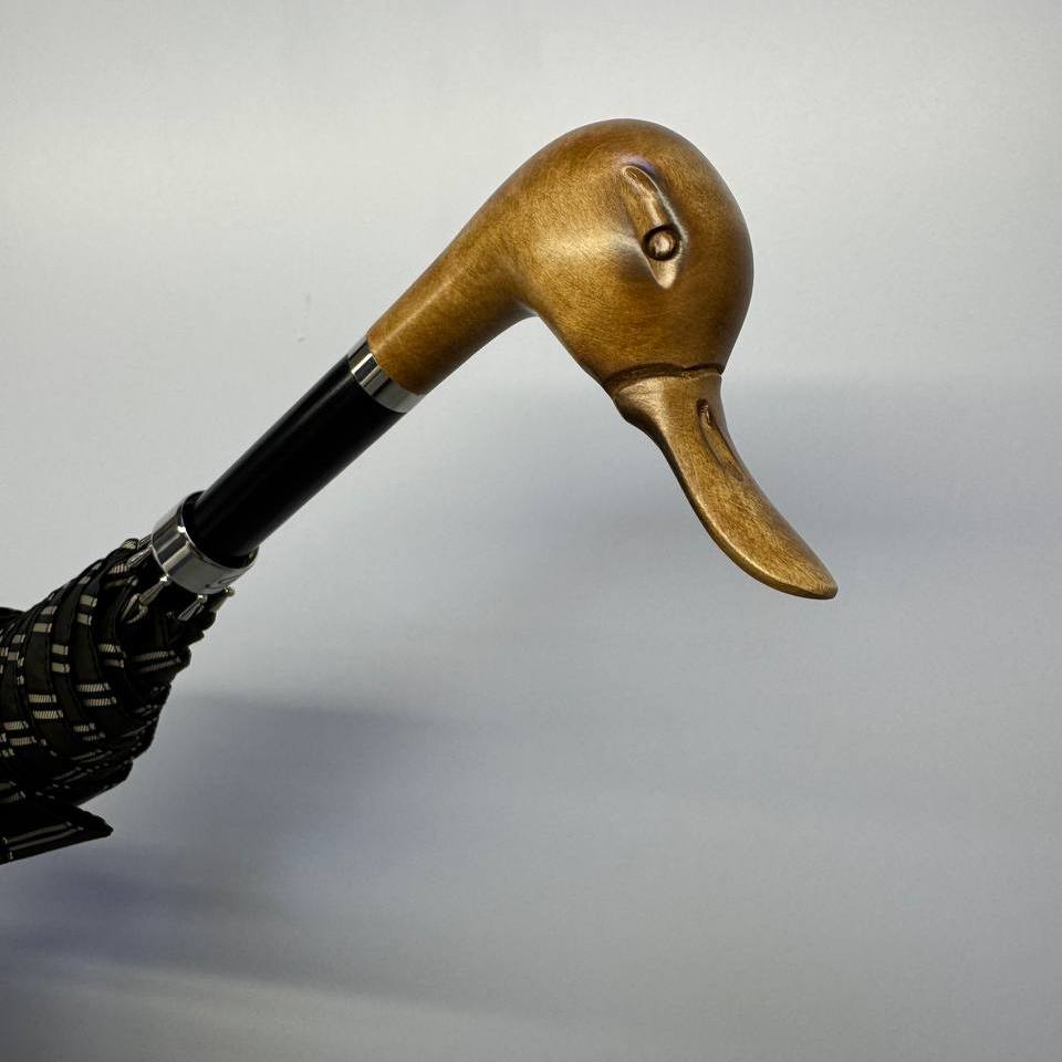 Duck head handle seen from above, with the furled striped canopy below