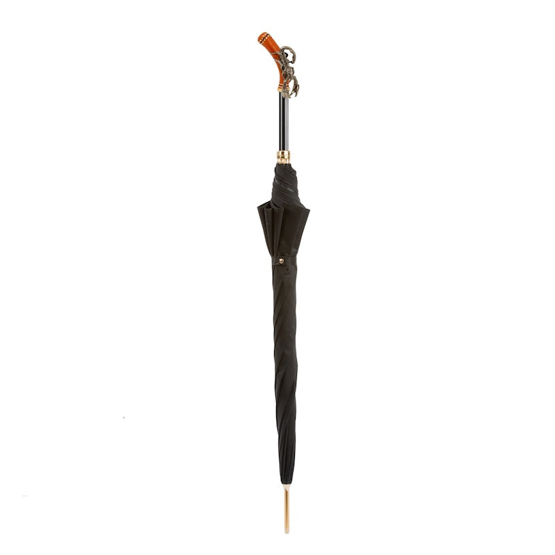 Closed black umbrella standing upright with the scorpion handle on top
