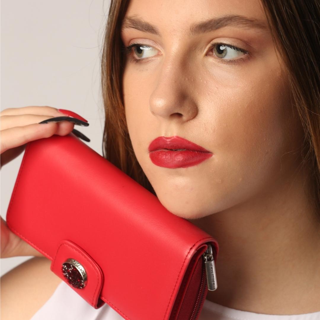 Model holding the red Tony Perotti wallet — crystal medallion and engraved zip pull