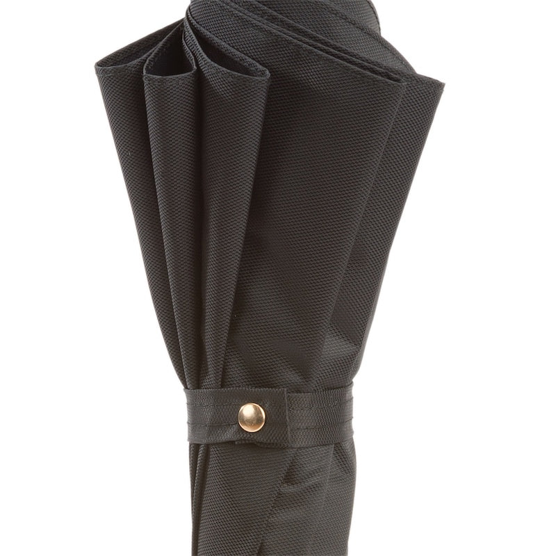 Furled canopy close-up: textured black fabric and strap with gold-tone snap button