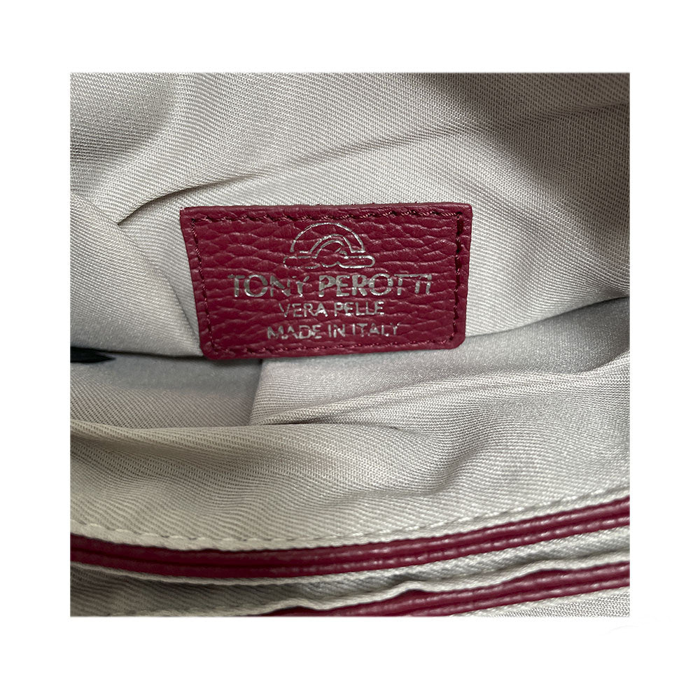 The Tony Perotti Vera Pelle Made in Italy leather label sewn onto the greyish beige textile lining inside the bag