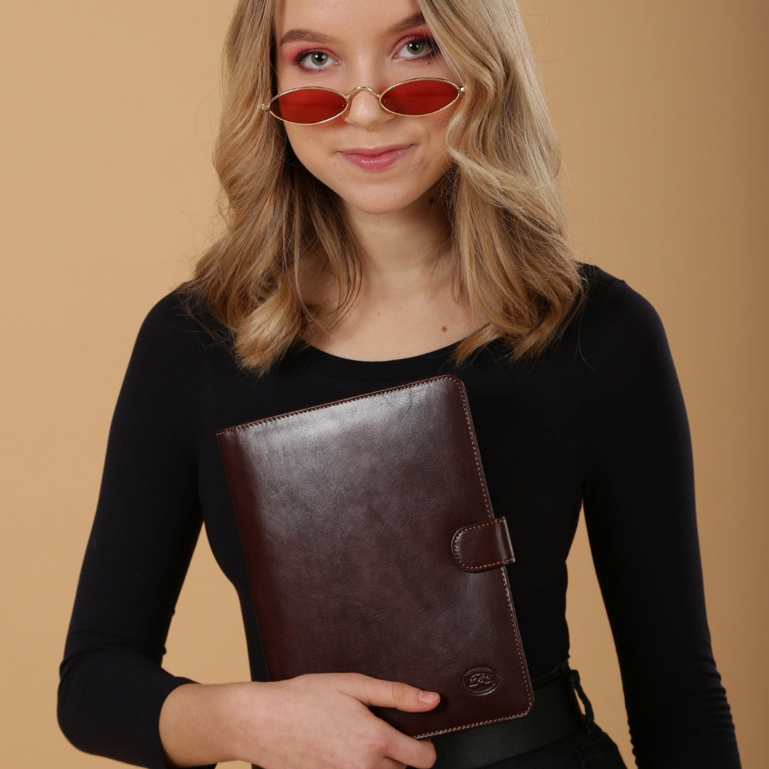 Model holding the closed dark brown Italico 2590 — scale in the hand and the tab closure