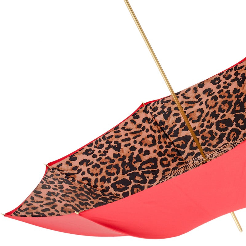 Underside of the open canopy: leopard print inside, red edge and gold-tone shaft
