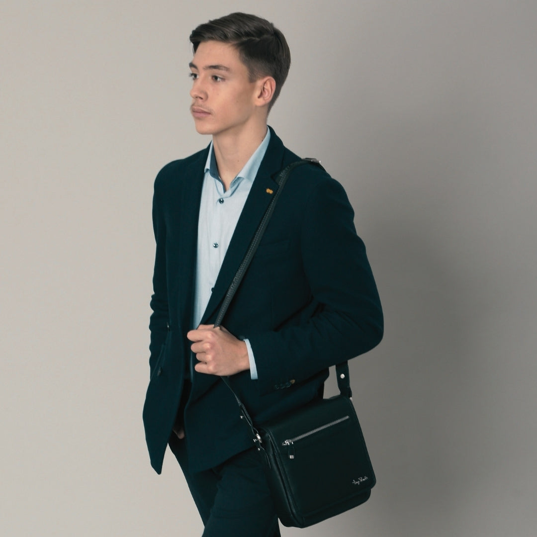 Man in a dark suit wearing the black Tony Perotti Contatto 9027-20 messenger bag across the body