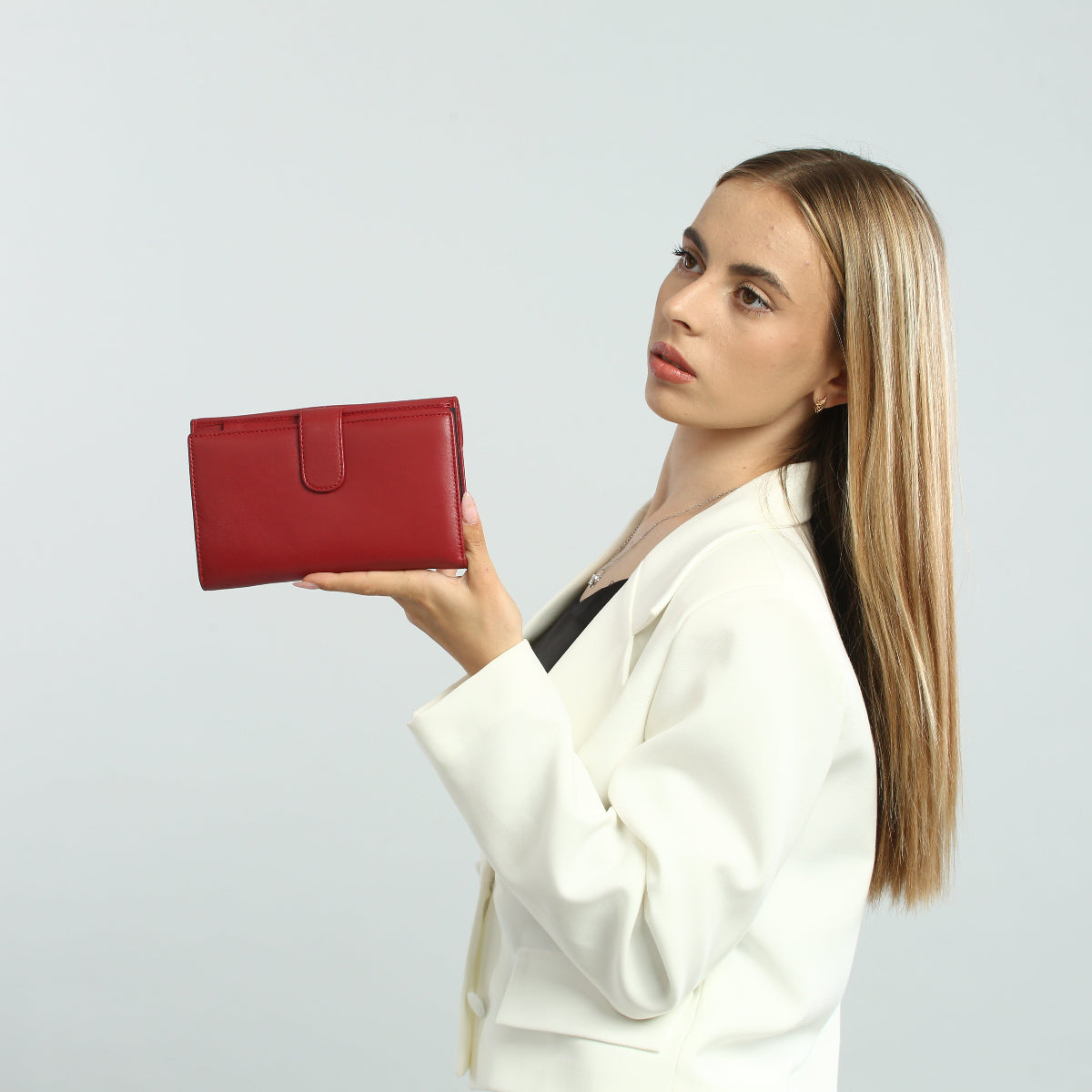 Model holding the red Tony Perotti Cortina 5073 wallet on an open palm — the side with the snap tab