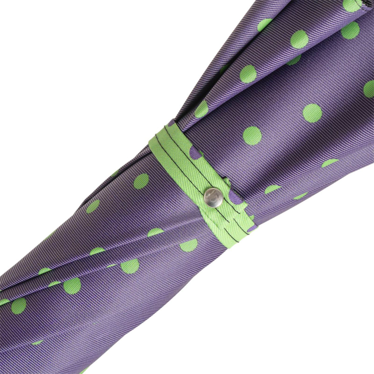 Green strap with silver-tone snap button on the furled purple canopy with green dots