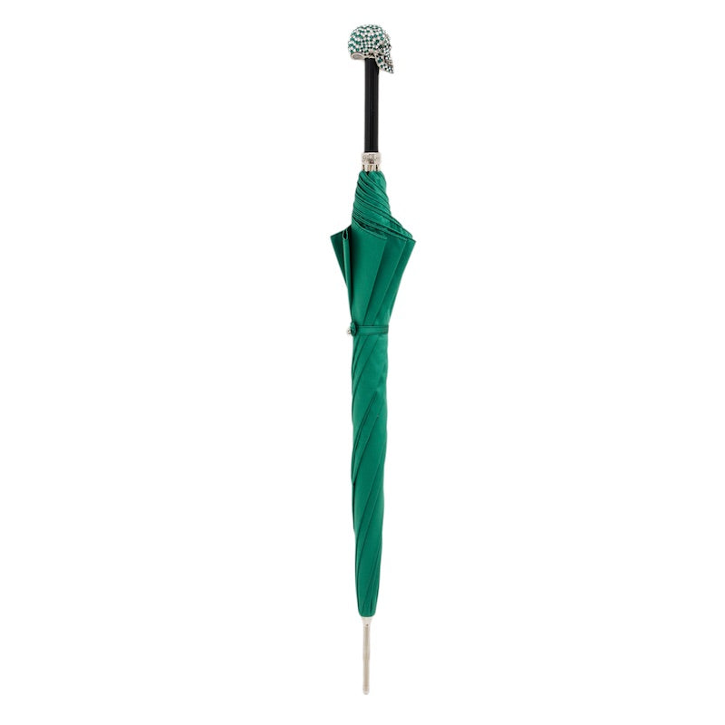 Closed green umbrella standing upright with the crystal skull handle and silver-tone tip