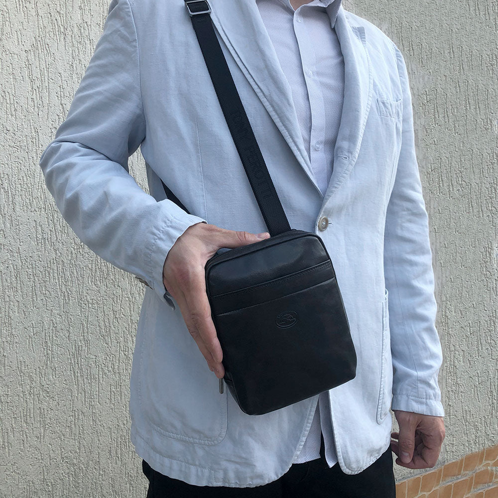 Man wearing the small black Tony Perotti Italico 6056 crossbody bag on the branded jacquard strap
