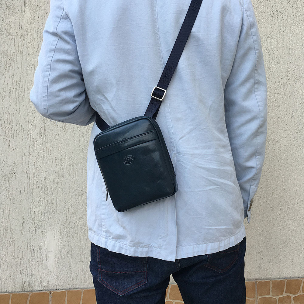 Man wearing the small navy Tony Perotti Italico 6056 crossbody bag on his back on the branded strap