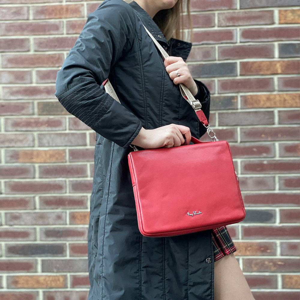 Contatto 9594-28 rosso carried on the shoulder, held by the raised leather handle