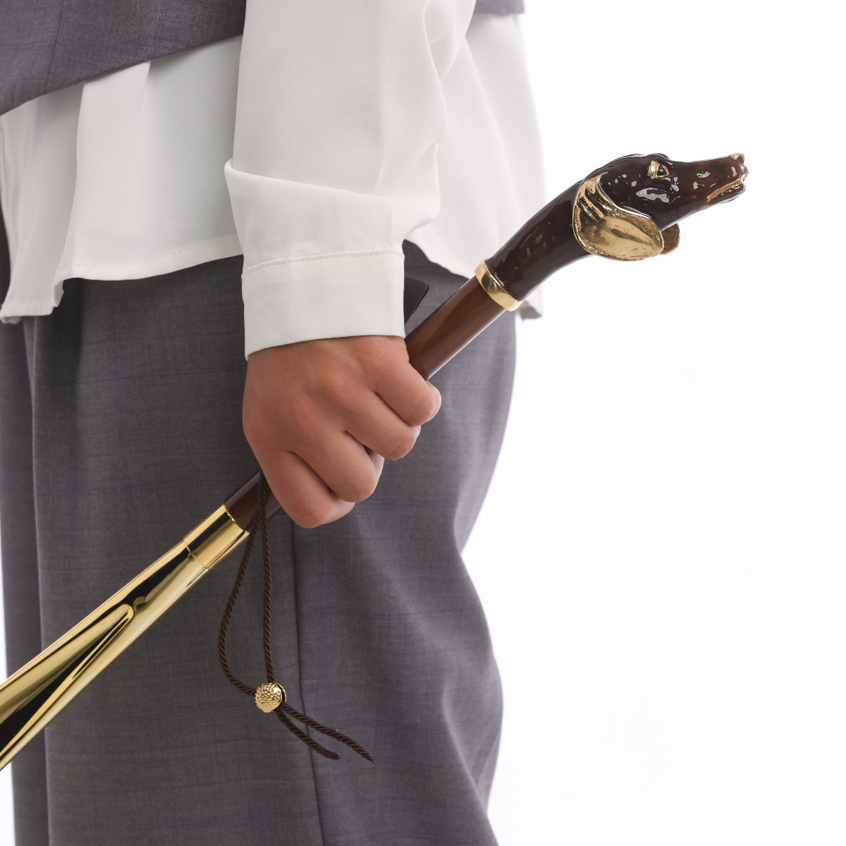 Hand holding the dachshund shoehorn: enameled dog head with gold-tone ear and hanging cord