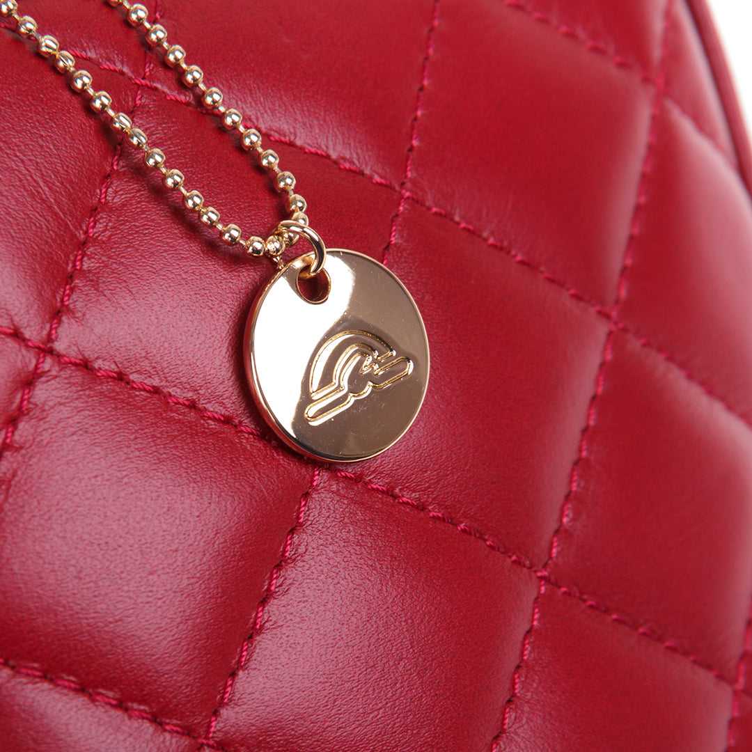 Close-up of the zip pull on the Tony Perotti Borsa CA006-01DR bag — a gold ball chain with a round Tony Perotti disc charm against the quilted red leather