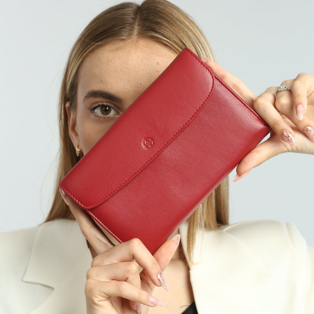 Model holding the closed red Tony Perotti Cortina 5073 wallet up in both hands, showing its width